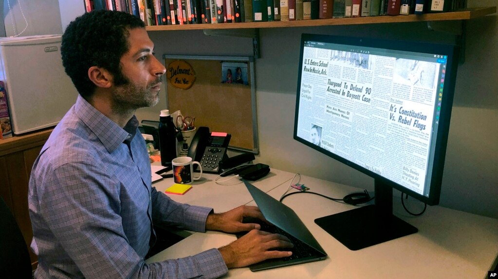 In this Monday, Feb. 24, 2020, photo, Dartmouth College's Matthew Delmont views the website he created, Black Quotidian, in his office on the school's campus in Hanover, N.H. (AP Photo/Michael Casey)