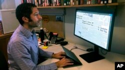 In this Monday, Feb. 24, 2020, photo, Dartmouth College's Matthew Delmont views the website he created, Black Quotidian, in his office on the school's campus in Hanover, N.H. (AP Photo/Michael Casey)