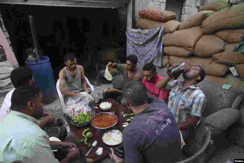 Para anggota Tentara Pembebasan Suriah berbuka puasa di daerah Karm al-Jabal, Aleppo (21/7).