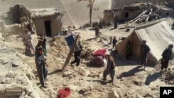 Rescuers have struggled to reach quake-struck zones like this one, where Afghan men remove personal belongings from Takhar province homes, northeast of Kabul, Oct. 27, 2015.