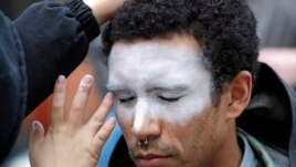In this Oct. 31, 2018, file photo, a man, who declined to be identified, has his face painted to represent efforts to defeat facial recognition during a protest at Amazon headquarters over the company's facial recognition system, 