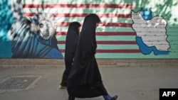 Иранские женщины проходят мимо антиамериканской фрески на стене бывшего посольства США в Тегеране. Октябрь 2011г.