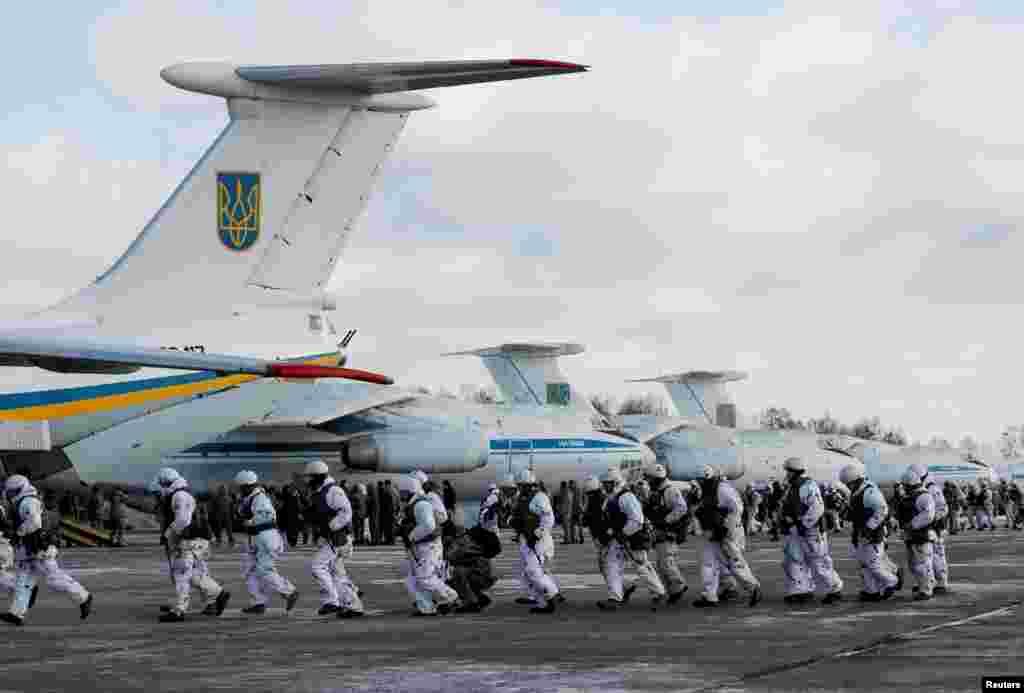 Ukrainian paratroopers board military planes before departing to the eastern regions of the country for a mission in the region at an air force base near Zhytomyr.