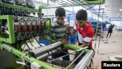 Palestinians work at a textile factory in the Industrial Park of the West Bank Jewish settlement of Barkan, Nov. 8, 2015. 