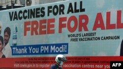 A motorist drives past a billboard advertising free COVID-19 vaccines for all citizens near a vaccination center in Mumbai, September 14, 2021.
