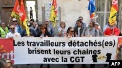 Des membres de la CGT tiennent une banderole portant l'inscription "Des travailleurs détachés brisent leurs chaînes" afin de soutenir cinq travailleurs détachés marocains à Arles, France, le 4 octobre 2018.