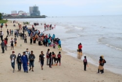 Warga berkumpul di pantai untuk membersihkan pantai dari tumpahan minyak di Pantai Kilang Mandiri di Balikpapan, Kalimantan Timur, 4 April 2018. (Foto: Antara/Sheravim via REUTERS)