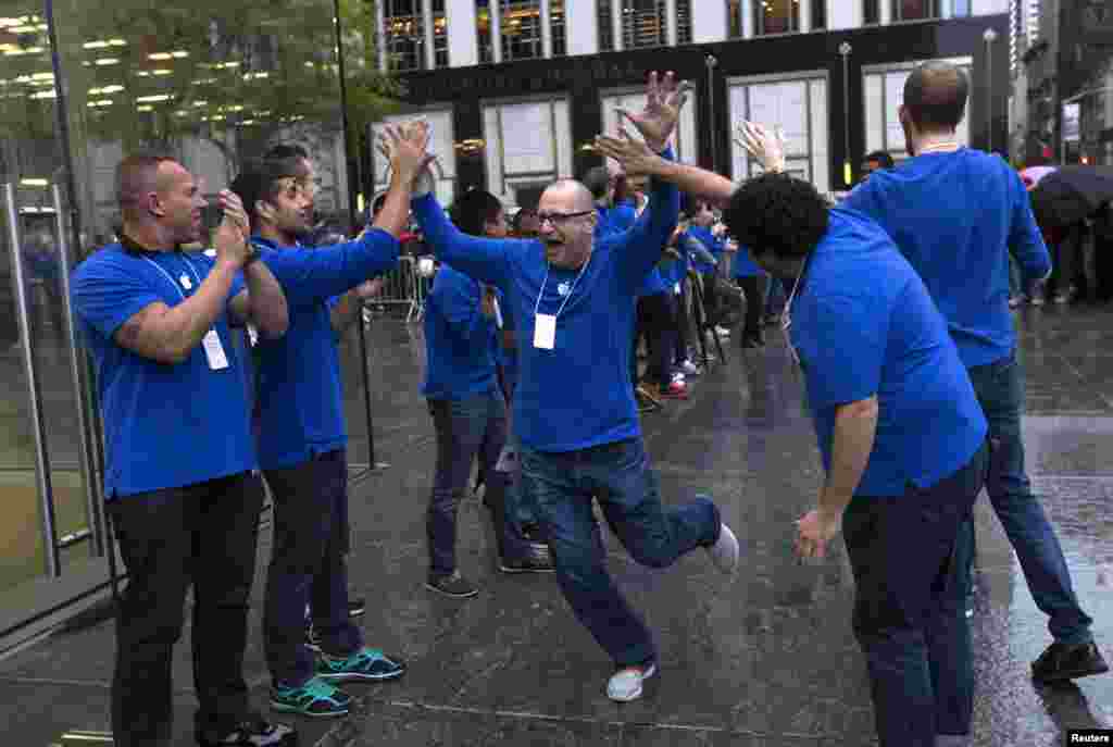 Para karyawan perusahaan Apple mengadakan perayaan di luar toko Apple di 5th Avenue New York, sesaat sebelum peluncuran penjualan tablet Apple iPad Air yang baru.