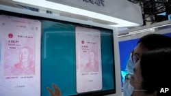 在中国北京的一个贸易展览会上，参观者在看电子人民币（2021年9月5日）。