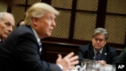 FILE - Then-White House Chief Strategist Steve Bannon listens at right as President Donald Trump speaks in the Roosevelt Room of the White House in Washington, Jan. 31, 2017.