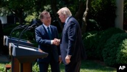 South Korean President Moon Jae-in shakes hands with President Donald Trump, right, after making statements in the Rose Garden of the White House in Washington, June 30, 2017. 