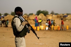 FILE - A Nigerien soldier stands guard in a camp of the city of Diffa during the visit of Niger's Interior Minister Mohamed Bazoum following attacks by Boko Haram fighters in the region of Diffa, June 18,2016.
