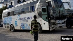 A man looks at a bus that drove into a parade of pedestrians in Gonaives, Haiti, March 12, 2017.