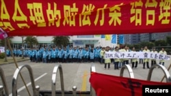 IBM workers shout slogans and hold banners as they protest at an IBM factory in Shenzhen, Guangdong province, March 7, 2014. 