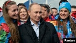 Russian President Vladimir Putin (C) and Olympic Village Mayor Elena Isinbaeva (R) visit the Coastal Cluster Olympic Village ahead of the Sochi 2014 Winter Olympics at the Athletes Village in Sochi, Feb. 5, 2014. 