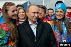 Russian President Vladimir Putin (C) and Olympic Village Mayor Elena Isinbaeva (R) visit the Coastal Cluster Olympic Village ahead of the Sochi 2014 Winter Olympics at the Athletes Village in Sochi, Feb. 5, 2014.