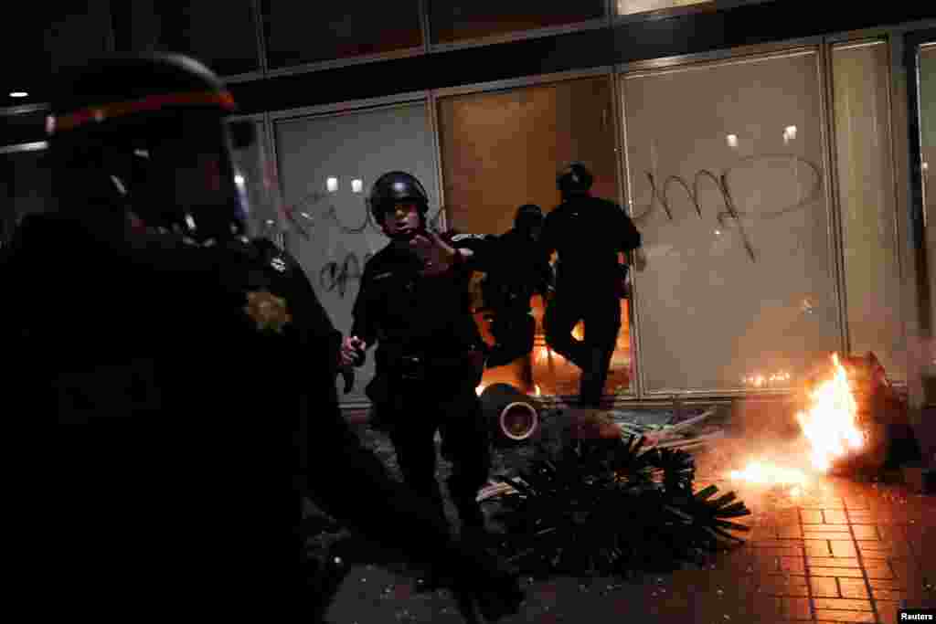 Police officers work to control the scene of an office set aflame by demonstrators during a demonstration in Oakland, California, U.S. following the election of Donald Trump as president, Nov. 9, 2016.