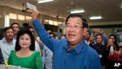 FILE - Prime Minister Hun Sen of the Cambodian People's Party shows off his ballot paper before voting in local elections at Takhmau polling station in Kandal province, southeast of Phnom Penh, June 4, 2017. 