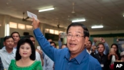 FILE - Prime Minister Hun Sen of the Cambodian People's Party shows off his ballot paper before voting in local elections at Takhmau polling station in Kandal province, southeast of Phnom Penh, June 4, 2017. 
