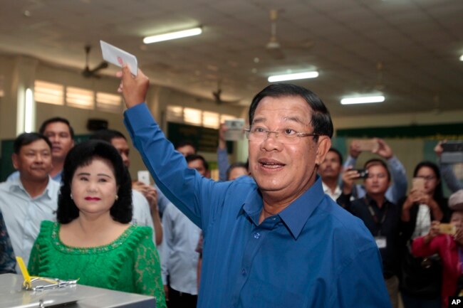 FILE - Prime Minister Hun Sen of the Cambodian People's Party shows off his ballot paper before voting in local elections at Takhmau polling station in Kandal province, southeast of Phnom Penh, June 4, 2017.