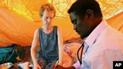 A photo made on 28 Jan 2010 shows Briton Rachel Chandler (L) being examined by Somali doctor Abdi Mohamed Helmi (R) at a location in central Somalia, where she is being held since she and her husband Paul were kidnapped as they sailed their yacht, the Lyn