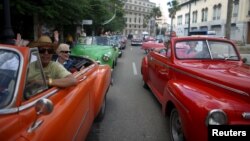 Tourists enjoy a ride in vintage cars in old Havana, Cuba, Jan. 17, 2016.
