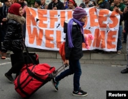 Migrants are welcomed as they arrive at the main railway station in Dortmund, Germany, Sept. 6, 2015.