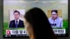 一名女子走过韩国首尔火车站正在播放韩国总统文在寅（左）和朝鲜领导人金正恩画面的电视屏幕。（2018年3月29日）