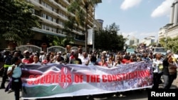 FILE - Members of Kenya's ruling Jubilee Coalition carry a banner as they demonstrate in support of the Independent Electoral and Boundaries Commission in Nairobi, Kenya, June 8, 2016. 