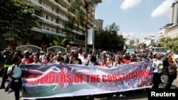 FILE - Members of Kenya's ruling Jubilee coalition carry a banner as they demonstrate in support of the Independent Electoral and Boundaries Commission (IEBC) the electoral body ahead of next year's election in Nairobi, Kenya, June 8, 2016. 