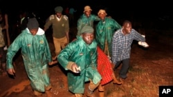 Members of the National Youth Service carry away a dead body covered in a blanket during the early hours of May 10, 2018 near Solai, in Kenya's Rift Valley. 