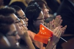Para siswa bertepuk tangan saat Presiden China Xi Jinping memberikan pidato saat berkunjung ke Lincoln High School di Tacoma, Washington, 23 September 2015. (Foto: REUTERS/David Ryder)