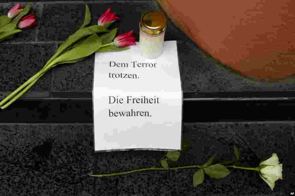 Flowers, a candle and a letter with the words 'Defy Terror' - ' Preserve Freedom' are placed in front of the Belgian Embassy in Berlin, Germany, March 22, 2016 after the attacks in Brussels. 