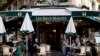 Pelanggan duduk di teras kafe dan restoran Les Deux Magots di Paris yang dibuka kembali setelah tutup selama berbulan-bulan di tengah pandemi COVID-19 di Perancis, 19 Mei 2021. (REUTERS / Christian Hartmann)