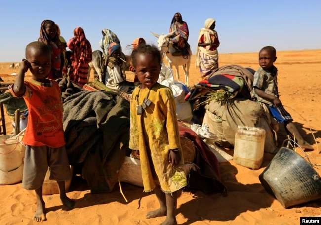 FILE - People set down their belongings as they arrive at the Zamzam IDP camp for Internally Displaced Persons (IDP), near El Fasher in North Darfur, Feb. 4, 2015.