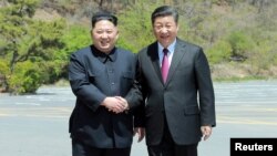 North Korean leader Kim Jong Un shakes hands with China's President Xi Jinping, in Dalian, China in this undated photo released on May 9, 2018 by North Korea's Korean Central News Agency (KCNA).