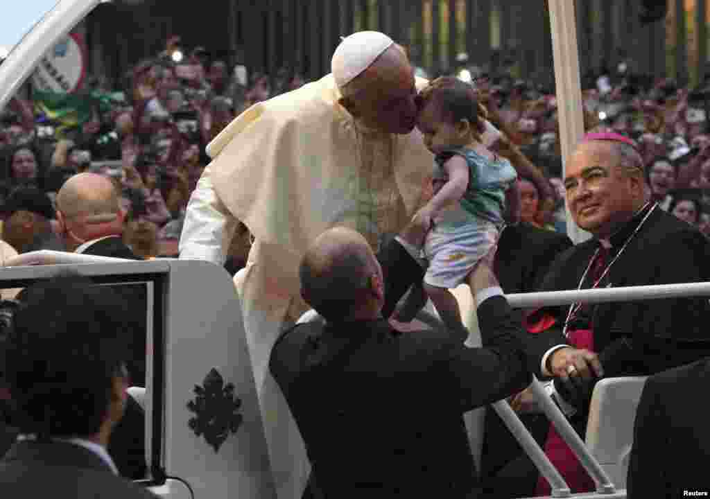 Papa Francisco desfila pelas ruas do centro do Rio de Janeiro acenando e abençoando a multidão de fiéis que compareceu as ruas da cidade maravilhosa na segunda-feira.