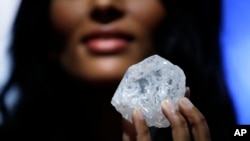 A large diamond is displayed at Sotheby's in New York, May 4, 2016. The three-billion-year-old diamond is the size of a tennis ball. It is the largest discovered in more than 100 years. Sotheby's says it could sell for more than $70 million. 