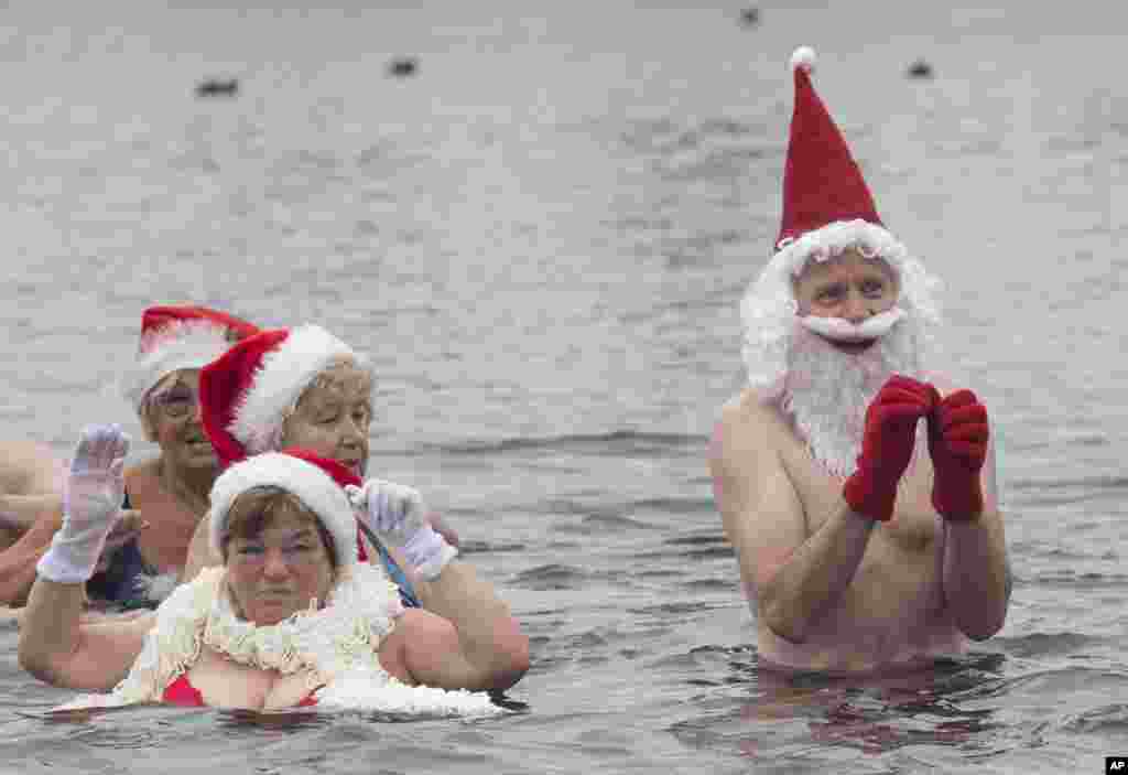 Members of the swimming club 'Berlin seals' wear Christmas costumes as they go for a swim in the Orankesee lake in Berlin, Germany, Dec. 25, 2018. 