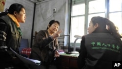 Chinese census workers gather data from an elderly resident at her home in Beijing. China kicked off its national census, with more than six million counters fanning out nationwide to tally the world's biggest population, 02 Nov. 2010.