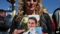 The wife of sailor Fernando Villarreal, a crew member of the missing submarine, shows his picture as she prays at the naval base in Mar de Plata, Argentina, Friday, Nov. 24, 2017.