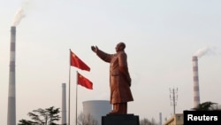 A statue of former Chinese leader Mao Zedong is seen in front of smoking chimneys at Wuhan Iron And Steel Corp in Wuhan, Hubei province, Mar. 6, 2013.