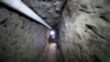 FILE - Federal Police officer stands in the tunnel where drug lord Joaquin "El Chapo" Guzman made his escape from the Altiplano maximum security prison in Almoloya, west of Mexico City, July 16, 2015.