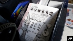 FILE - A Powerball lottery ticket is printed out of a lottery machine at a convenience store in Chicago, Illinois. 