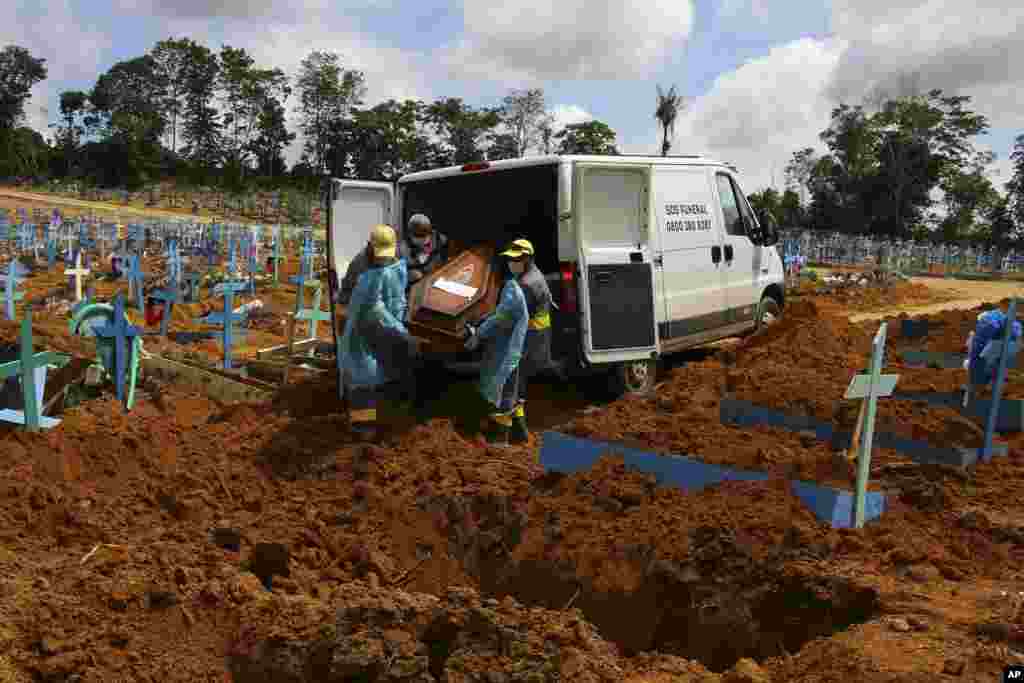 Cemetery workers carry the remains of 89-year-old Abilio Ribeiro, who died of the new coronavirus, to bury at the Nossa Senhora Aparecida cemetery in Manaus, Amazonas state, Brazil.