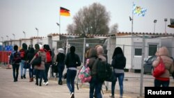 FILE - Eritrean migrants walk after arriving by plane from Italy at the first registration camp in Erding near Munich, Germany, Nov. 15, 2016. 
