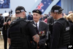 British D-Day veteran Jim Booth speaks to police officers as he arrives for an event to mark the 75th anniversary of D-Day in Portsmouth, England, June 5, 2019.