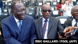 Le président guinéen Alpha Condé (à dr.) avec son homologue ivoirien Alassane Ouattara lors d'une cérémonie marquant le 75e anniversaire du débarquement allié en Provence pendant la Seconde Guerre mondiale, à Saint-Raphaël, en France, le 15 août 2019.