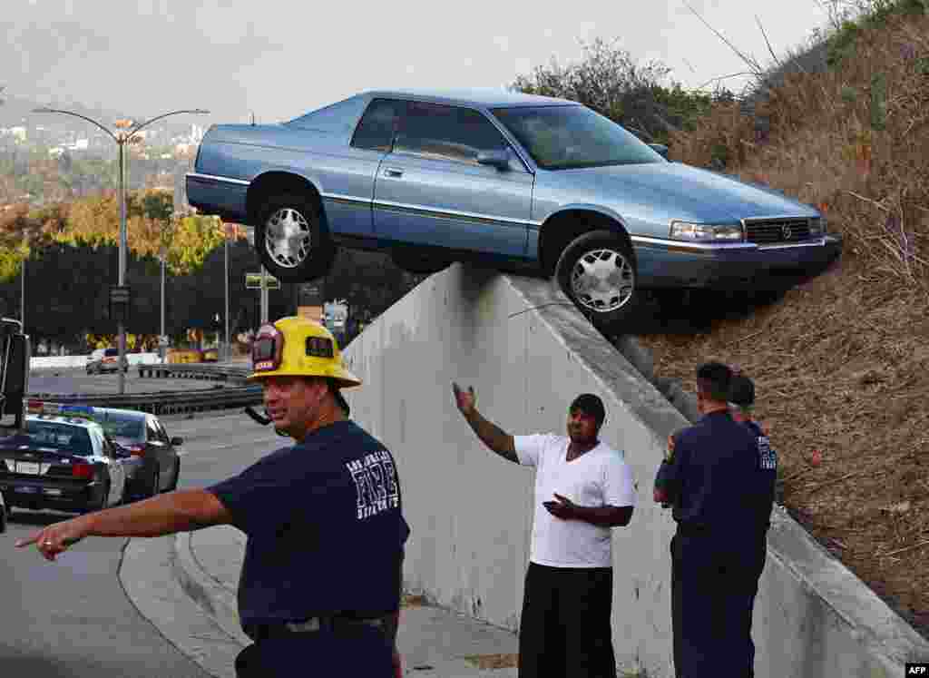 A car sits atop an embankment after losing control and skidding up the concrete retaining wall on South La Brea Ave in Baldwin Hills, Los Angeles, USA, Aug. 24, 2014. The driver and his passenger escaped injury.