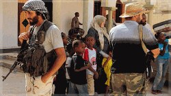 Un combattant révolutionnaire monte la garde devant une mosquée à Syrte, alors que des familles tentent de sortir de la ville (26 septembre 2011)
